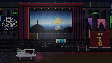 A darkened screening stage with a lit cinema screen behind red curtains, empty seating in front of it and exit signs glowing green on both walls.